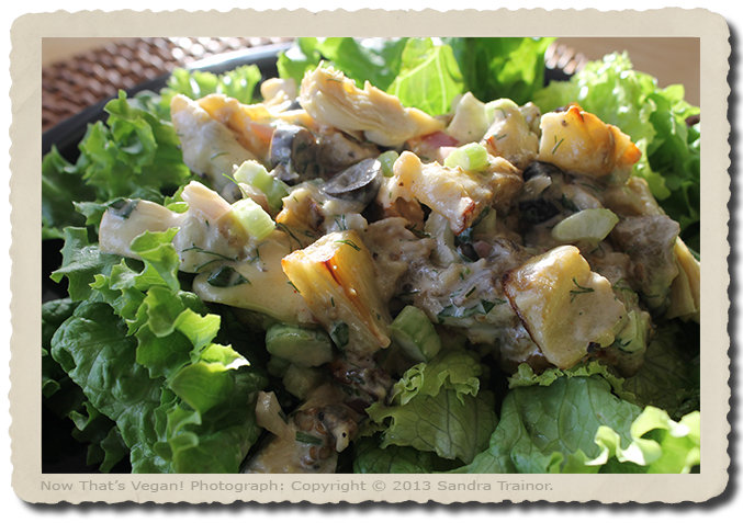 A bed of lettuce topped with baked eggplant, artichokes, olives, and a creamy dressing.